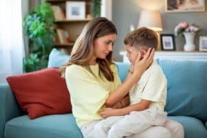 Parent accompagnant avec calme les émotions de son enfant lors d'un moment difficile