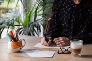 Personne écrivant une lettre de pardon pour exprimer ses émotions et commencer à faire la paix avec son passé