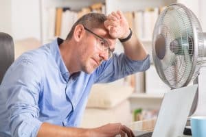 Salarié se protégeant de la chaleur au travail sans climatisation pendant la canicule