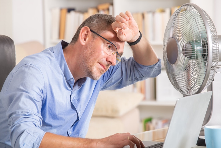 Salarié se protégeant de la chaleur au travail sans climatisation pendant la canicule